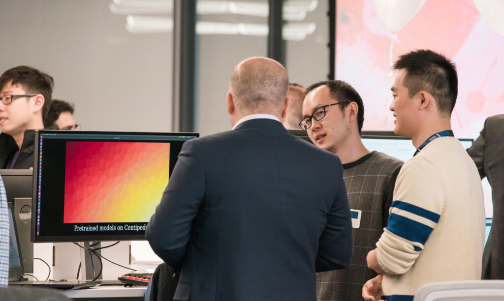 Researchers talking around a computer