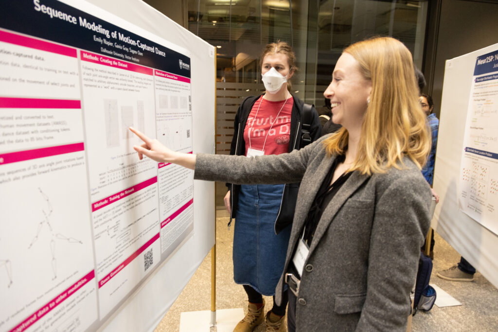 Vector researchers discuss a research posted at Vector's research symposium.