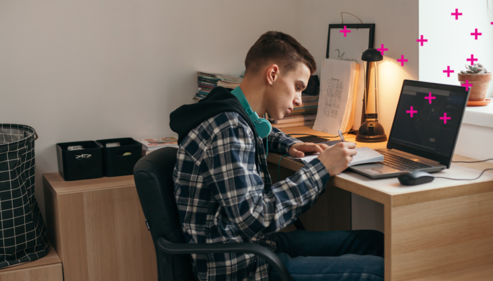 Boy in his room doing homework at a laptop