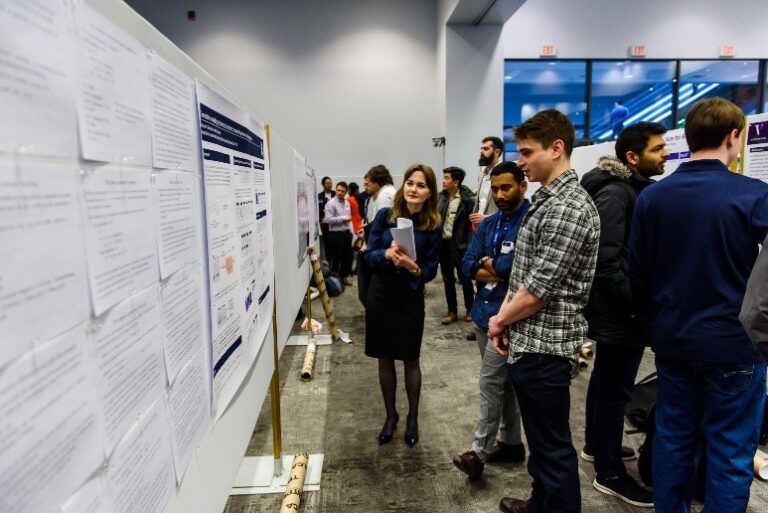 Woman and man staring at research posters at the Vector 2019 Research Symposium and Job Fair