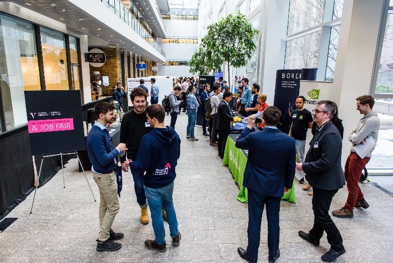 Wide shot of people discussing at the Vector 2019 Research Symposium and Job Fair